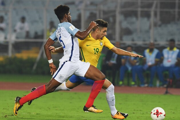 Jonathan Panzo of England (L) fights for the ball with  Yuri Alberto  of Brazil during the semifinal football match in the FIFA U-17 World Cup at the Vivekananda Yuba Bharati Krirangan stadium in Kolkata on October 25, 2017. / AFP PHOTO / Dibyangshu SARKAR        (Photo credit should read DIBYANGSHU SARKAR/AFP/Getty Images)