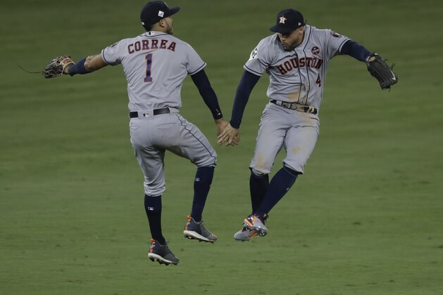 Houston Astros' George Springer and Carlos Correa celebrate after Game 2 of baseball's World Series against the Los Angeles Dodgers Wednesday, Oct. 25, 2017, in Los Angeles. The Astros won 7-6 to tie the series at 1-1. (AP Photo/Alex Gallardo)