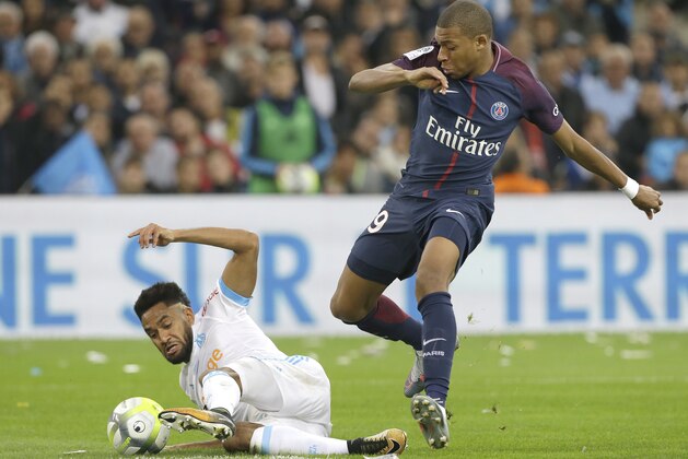 Marseille's Jordan Amavi, left, challenges for the ball with PSG's Kylian Mbappe during the League One soccer match between Marseille and Paris Saint-Germain, at the Velodrome stadium, in Marseille, southern France, Sunday, Oct. 22, 2017. (AP Photo/Claude Paris)