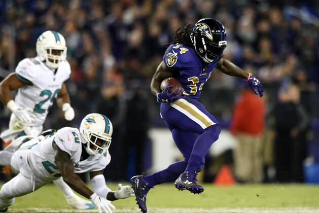 Baltimore Ravens running back Alex Collins (34) rushes past Miami Dolphins defenders in the first half of an NFL football game, Thursday, Oct. 26, 2017, in Baltimore. (AP Photo/Gail Burton)