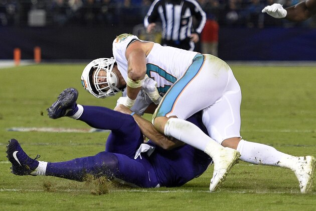 Miami Dolphins middle linebacker Kiko Alonso, top, collides with Baltimore Ravens quarterback Joe Flacco as Flacco slides on the field after rushing the ball in the first half of an NFL football game, Thursday, Oct. 26, 2017, in Baltimore. (AP Photo/Nick Wass)
