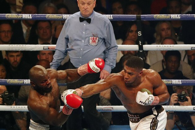 Cameroon-born Carlos Takam (L) recoils from a straight right from Britain's Anthony Joshua (R) during their world heavyweight title fight at The Principality Stadium in Cardiff on October 28, 2017.
Joshua stopped Takam in 10th round to retain his championship belts.  / AFP PHOTO / ADRIAN DENNIS        (Photo credit should read ADRIAN DENNIS/AFP/Getty Images)