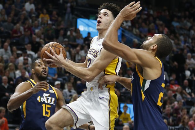 Los Angeles Lakers guard Lonzo Ball, center, drives to the basket as Utah Jazz's Derrick Favors (15) and Rudy Gobert, right, defend in the first half during an NBA basketball game Saturday, Oct. 28, 2017, in Salt Lake City. (AP Photo/Rick Bowmer)