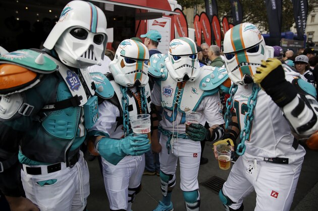 Miami Dolphins fans calling themselves the Fintroopers pose for photographs in their Star Wars Miami Dolphins themed costumes during an NFL fan rally in Trafalgar Square, in London, Saturday, Oct. 3, 2015. The New York Jets are preparing for an NFL football game against the Miami Dolphins at London's Wembley stadium on Sunday.  (AP Photo/Matt Dunham)