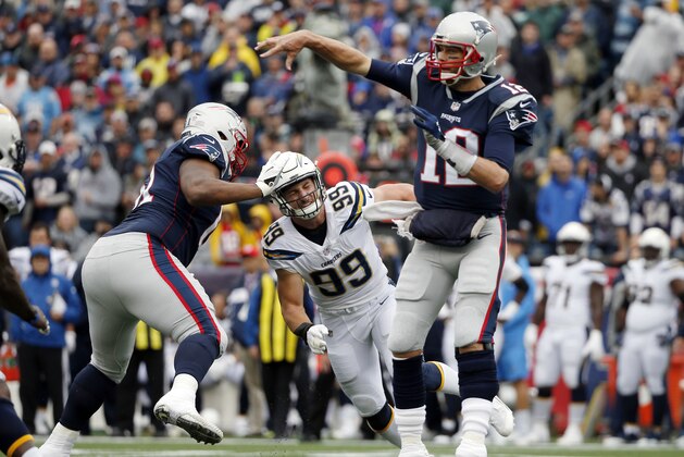 New England Patriots quarterback Tom Brady (12) passes under pressure from Los Angeles Chargers defensive end Joey Bosa (99) during the first half of an NFL football game, Sunday, Oct. 29, 2017, in Foxborough, Mass. (AP Photo/Michael Dwyer)