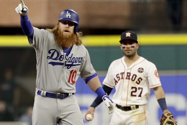 Los Angeles Dodgers' Justin Turner celebrates after a double as Houston Astros second baseman Jose Altuve looks on during the seventh inning of Game 5 of baseball's World Series Sunday, Oct. 29, 2017, in Houston. (AP Photo/Matt Slocum)