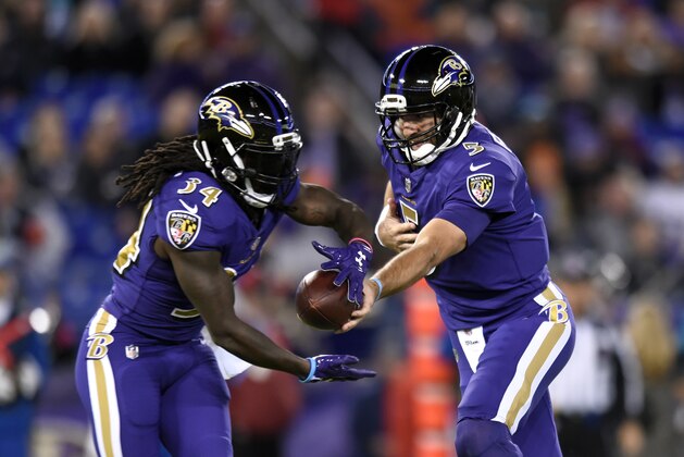 Baltimore Ravens quarterback Joe Flacco, right, hands off to Baltimore Ravens running back Alex Collins in the first half of an NFL football game against the Miami Dolphins, Thursday, Oct. 26, 2017, in Baltimore. (AP Photo/Gail Burton)