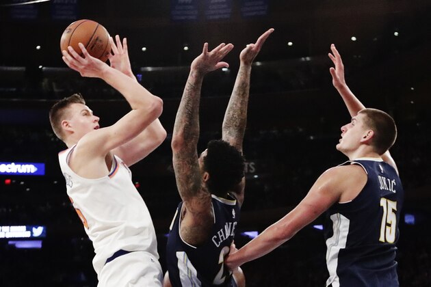 New York Knicks' Kristaps Porzingis, left, shoots over Denver Nuggets' Wilson Chandler, center, and Nikola Jokic, right, during the second half of an NBA basketball game Monday, Oct. 30, 2017, in New York. The Knicks won 116-110. (AP Photo/Frank Franklin II)
