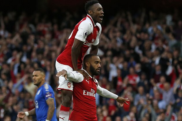 Arsenal's French striker Alexandre Lacazette celebrates with Arsenal's English striker Danny Welbeck (up) after scoring the opening goal of the English Premier League football match between Arsenal and Leicester City at the Emirates Stadium in London on August 11, 2017. / AFP PHOTO / Ian KINGTON / RESTRICTED TO EDITORIAL USE. No use with unauthorized audio, video, data, fixture lists, club/league logos or 'live' services. Online in-match use limited to 75 images, no video emulation. No use in betting, games or single club/league/player publications.  /         (Photo credit should read IAN KINGTON/AFP/Getty Images)
