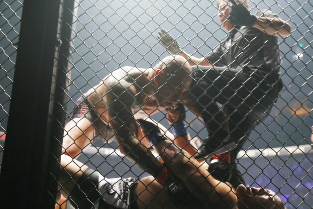 The referee tries to stop the fight as the Philippines' Brandon Vera pins down Japanese Hideki Sekine in their MMA (Mixed Martial Arts) One Heavyweight World Championship title fight Friday, Dec. 2, 2016, at the Mall of Asia Arena in suburban Pasay city south of Manila, Philippines. Vera retained his title after defeating Sekine in the first round of their scheduled five-round fight. (AP Photo/Bullit Marquez)