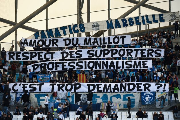 TOPSHOT - Olympique de Marseille (OM) fans hold a banner reading 'for the love of the OM jersey, the respect of fans and professionalism, is it too much to ask?', prior to the start of the French L1 football match between Olympique de Marseille (OM) and Caen at the Velodrome stadium in Marseille on November 5, 2017.   
Marseille, in fifth, host Caen at the Velodrome in an atmosphere made tense after Patrice Evra was suspended by the club for aiming a karate kick at the head of one of his team's own supporters. / AFP PHOTO / BORIS HORVAT        (Photo credit should read BORIS HORVAT/AFP/Getty Images)