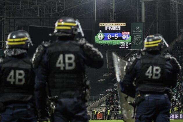 French riot police stand on the sideline of the pitch after fans interrupted the match  during the French L1 football match between AS Saint-Etienne and Olympique Lyonnais, on November 5, 2017, at the Geoffroy Guichard stadium in Saint-Etienne, central France.    / AFP PHOTO / JEFF PACHOUD        (Photo credit should read JEFF PACHOUD/AFP/Getty Images)