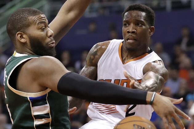 Phoenix Suns guard Eric Bledsoe (2) passes around Milwaukee Bucks center Greg Monroe during the second half of an NBA basketball game, Saturday, Feb. 4, 2017, in Phoenix. (AP Photo/Matt York)