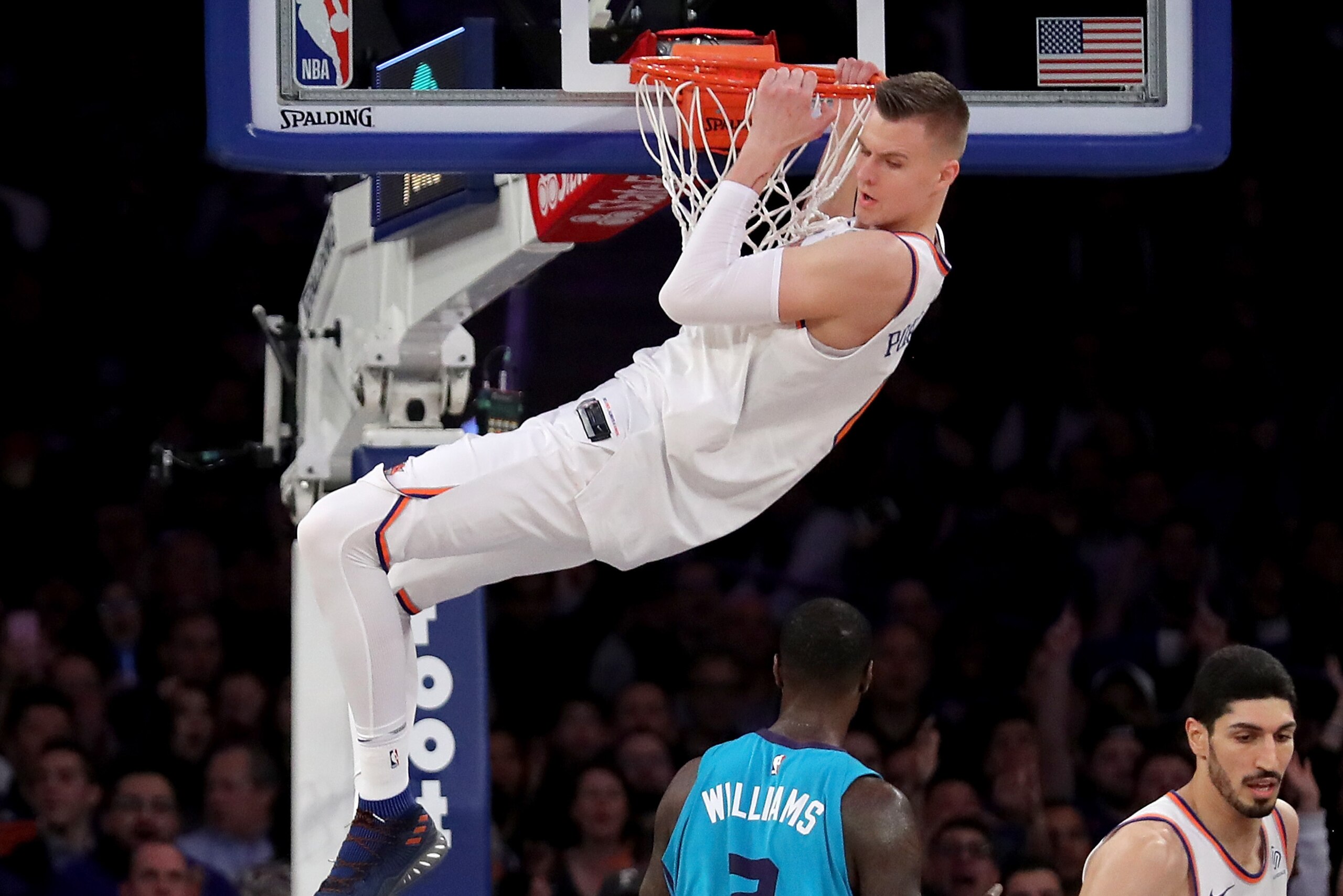 NEW YORK, NY - NOVEMBER 07: Kristaps Porzingis #6 of the New York Knicks hangs on the rim after dunking the ball in the second quarter against the Charlotte Hornets during their game at Madison Square Garden on November 7, 2017 in New York City. NOTE TO USER: User expressly acknowledges and agrees that, by downloading and or using this photograph, User is consenting to the terms and conditions of the Getty Images License Agreement.  (Photo by Abbie Parr/Getty Images)