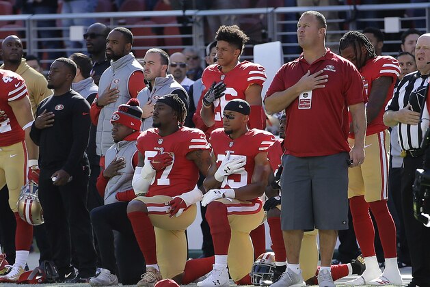 San Francisco 49ers outside linebacker Eli Harold, bottom center, and safety Eric Reid, bottom right, kneel during the national anthem before an NFL football game against the Arizona Cardinals in Santa Clara, Calif., Sunday, Nov. 5, 2017. (AP Photo/Jeff Chiu)