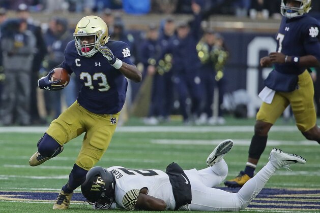 SOUTH BEND, IN - NOVEMBER 04:  Josh Adams #33 of the Notre Dame Fighting Irish breaks a tackle attempt by Cameron Glenn #2 of the Wake Forest Demon Deacons at Notre Dame Stadium on November 4, 2017 in South Bend, Indiana. Notre Dame defeated Wake Forest 48-37.  (Photo by Jonathan Daniel/Getty Images)