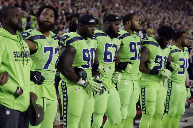 Members of the Seattle Seahawks stand during the national anthem prior to an NFL football game against the Arizona Cardinals, Thursday, Nov. 9, 2017, in Glendale, Ariz. (AP Photo/Rick Scuteri)