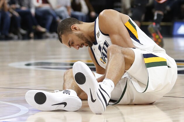 Utah Jazz center Rudy Gobert grabs his knee after being injured in the second half during an NBA basketball game against the Miami Heat, Friday, Nov. 10, 2017, in Salt Lake City. (AP Photo/Rick Bowmer)