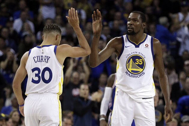 Golden State Warriors' Stephen Curry, left, and Kevin Durant (35) celebrate a score against the Philadelphia 76ers during the second half of an NBA basketball game Saturday, Nov. 11, 2017, in Oakland, Calif. Warriors won, 135-114. (AP Photo/Ben Margot)
