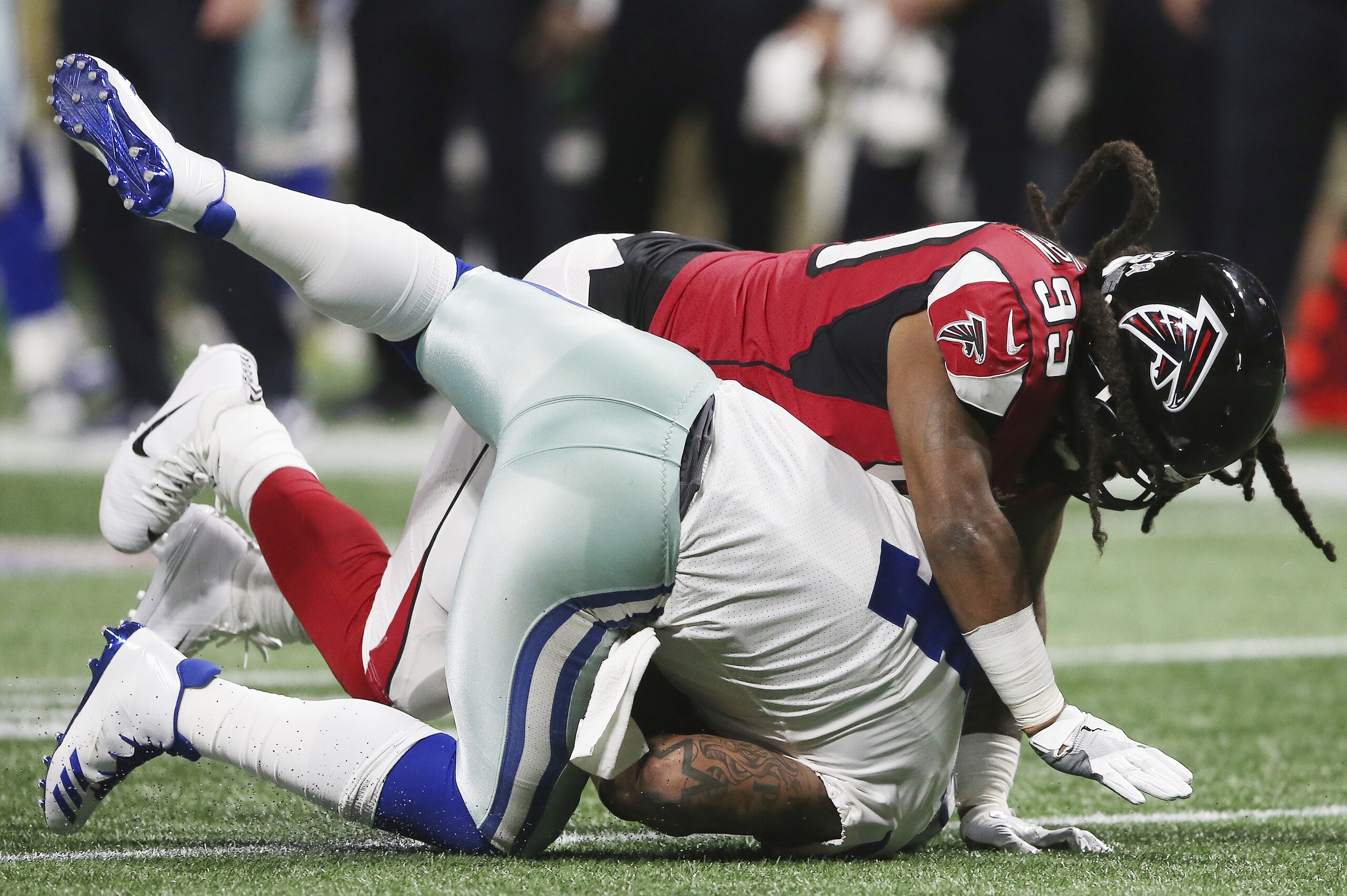 El defensive end Adrian Clayborn (99) de los Falcons de Atlanta derriba al quarterback Dak Prescott (4) de los Cowboys de Dallas, el domingo 12 de noviembre de 2017 (AP Foto/John Bazemore)