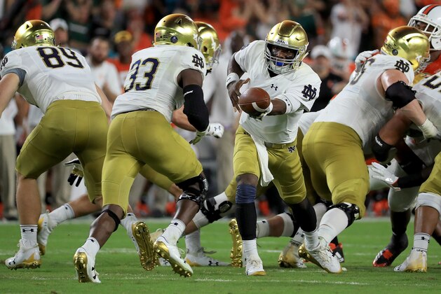 MIAMI GARDENS, FL - NOVEMBER 11:  Brandon Wimbush #7 of the Notre Dame Fighting Irish hands off to Josh Adams #33 during a game against the Miami Hurricanes at Hard Rock Stadium on November 11, 2017 in Miami Gardens, Florida.  (Photo by Mike Ehrmann/Getty Images)