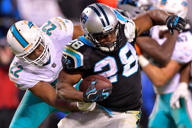 CHARLOTTE, NC - NOVEMBER 13:  T.J. McDonald #22 of the Miami Dolphins tackles Jonathan Stewart #28 of the Carolina Panthers during their game at Bank of America Stadium on November 13, 2017 in Charlotte, North Carolina.  (Photo by Grant Halverson/Getty Images)