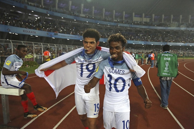 England's Morgan Gibbs White, left, and England's Angel Gomes bite their medals as they celebrates after their team won the FIFA U-17 World Cup in Kolkata, India, Saturday, Oct. 28, 2017. (AP Photo/Anupam Nath)