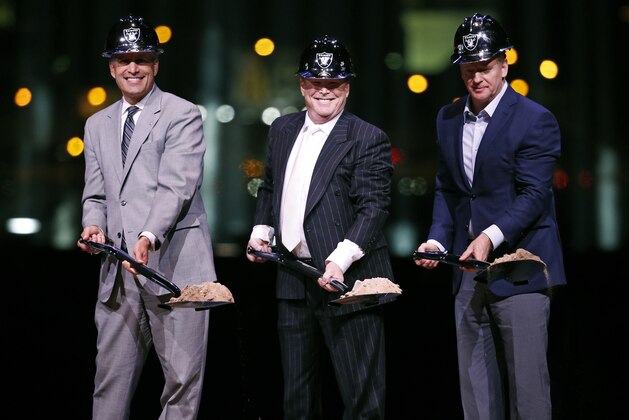 Raiders owner Mark Davis, center, poses for photographers beside Nevada Gov. Brian Sandoval, left, and NFL commissioner Roger Godell during a ceremonial groundbreaking for the Oakland Raiders' stadium Monday, Nov. 13, 2017, in Las Vegas. (AP Photo/John Locher)