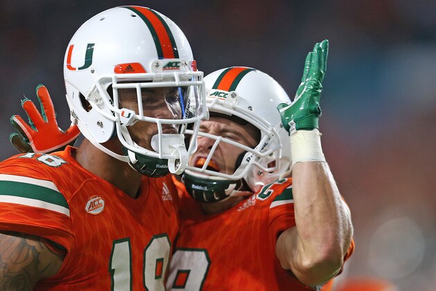 MIAMI GARDENS, FL - NOVEMBER 11: Lawrence Cager #18 is congratulated by Braxton Berrios #8 of the Miami Hurricanes after he ran 27 yards on a passing play against the Notre Dame Fighting Irish on November 11, 2017 at Hard Rock Stadium in Miami Gardens, Florida. Miami defeated Notre Dame 41-8. (Photo by Joel Auerbach/Getty Images)