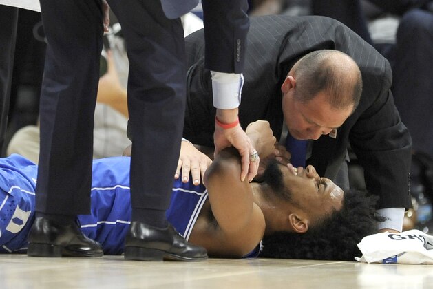 Duke assistant athletic trainer Jose Fonseca looks over forward Marvin Bagley III during the first half of the team's NCAA college basketball game against Michigan State on Tuesday, Nov. 14, 2017, in Chicago. (AP Photo/Paul Beaty)