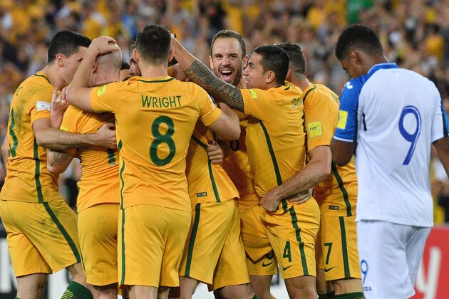 Australia's Mile Jedinak (obscured) is congratulated by teammates after scoring against Honduras in their 2018 World Cup qualification play-off football match at Stadium Australia in Sydney on November 15, 2017. / AFP PHOTO / Saeed KHAN / -- IMAGE RESTRICTED TO EDITORIAL USE - STRICTLY NO COMMERCIAL USE --        (Photo credit should read SAEED KHAN/AFP/Getty Images)