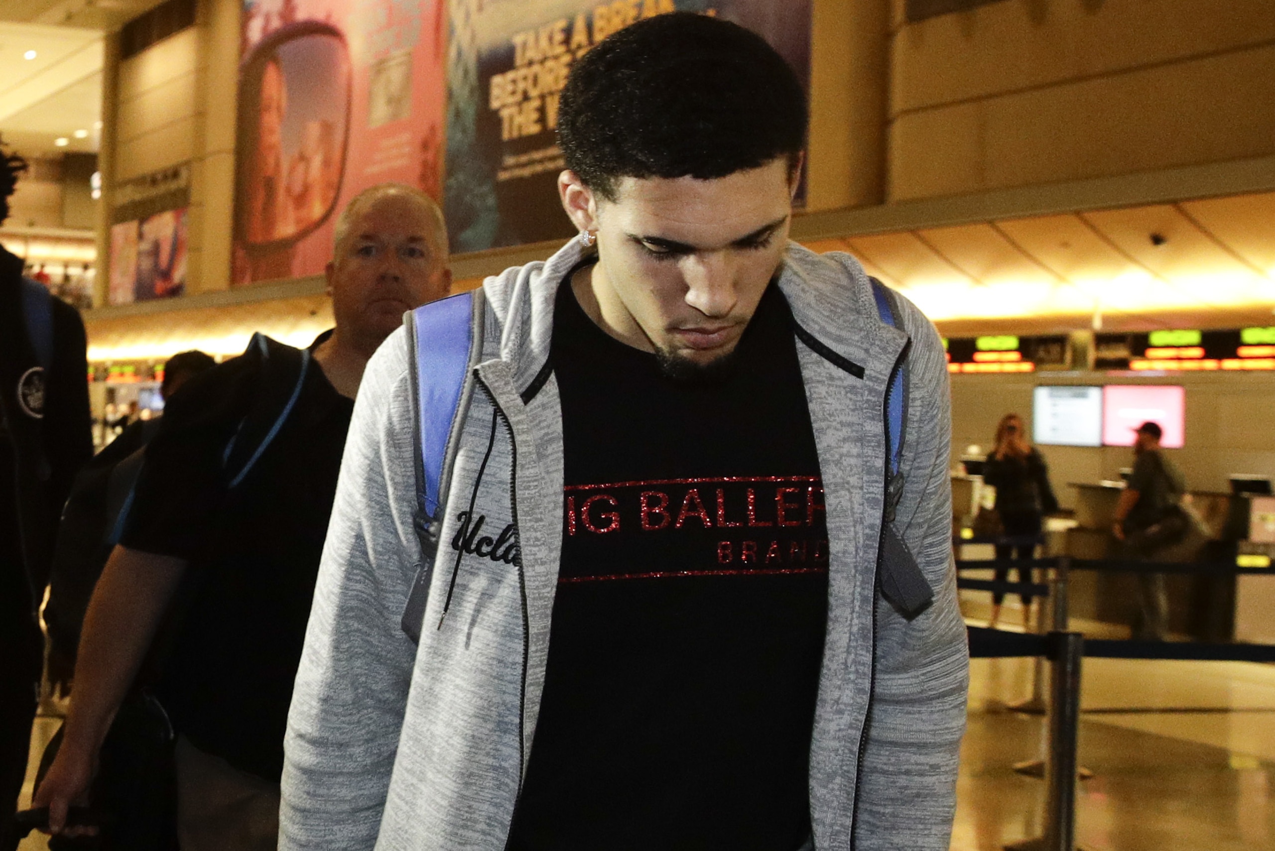 UCLA basketball player LiAngelo Ball keeps his head down as he leaves Los Angeles International Airport on Tuesday, Nov. 14, 2017, in Los Angeles. Three UCLA basketball players detained in China on suspicion of shoplifting returned home, where they may be disciplined by the school as a result of the international scandal. (AP Photo/Jae C. Hong)