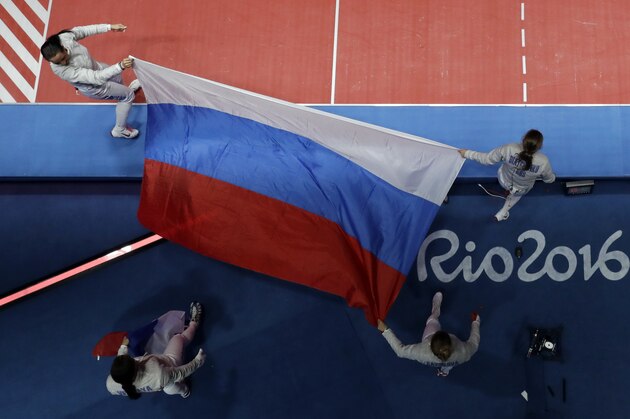 Ekaterina Dyachenko, Yana Egorian, Yuliya Gavrilova, and Sofya Velikaya of Russia hold their national flag after defeating Ukraine in a women's team sabre fencing final at the 2016 Summer Olympics in Rio de Janeiro, Brazil, Saturday, Aug. 13, 2016. (AP Photo/Andrew Medichini)