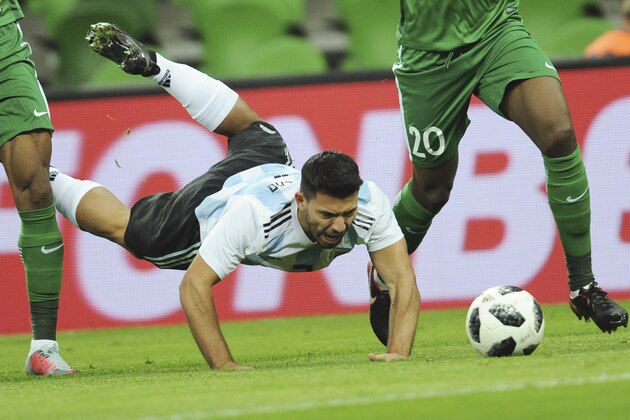 Argentina's Sergio Aguero, center, falls down as he challenges for the ball with Nigeria's Chidozie Awaziem, right, and John Obi Mikel, left, during the international friendly soccer match between Argentina and Nigeria in Krasnodar, Russia, Tuesday, Nov. 14, 2017. (AP Photo/Sergey Pivovarov)