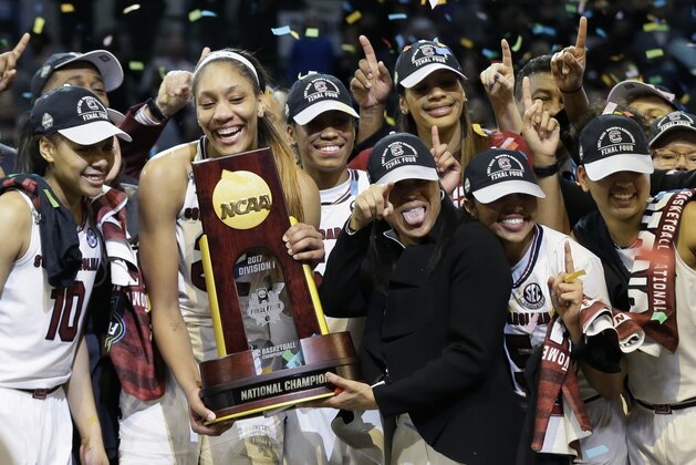 South Carolina forward A'ja Wilson holds the trophy and coach Dawn Staley points as the team celebrates a win over Mississippi State in the final of NCAA women's Final Four college basketball tournament, Sunday, April 2, 2017, in Dallas. South Carolina won 67-55. (AP Photo/Tony Gutierrez)