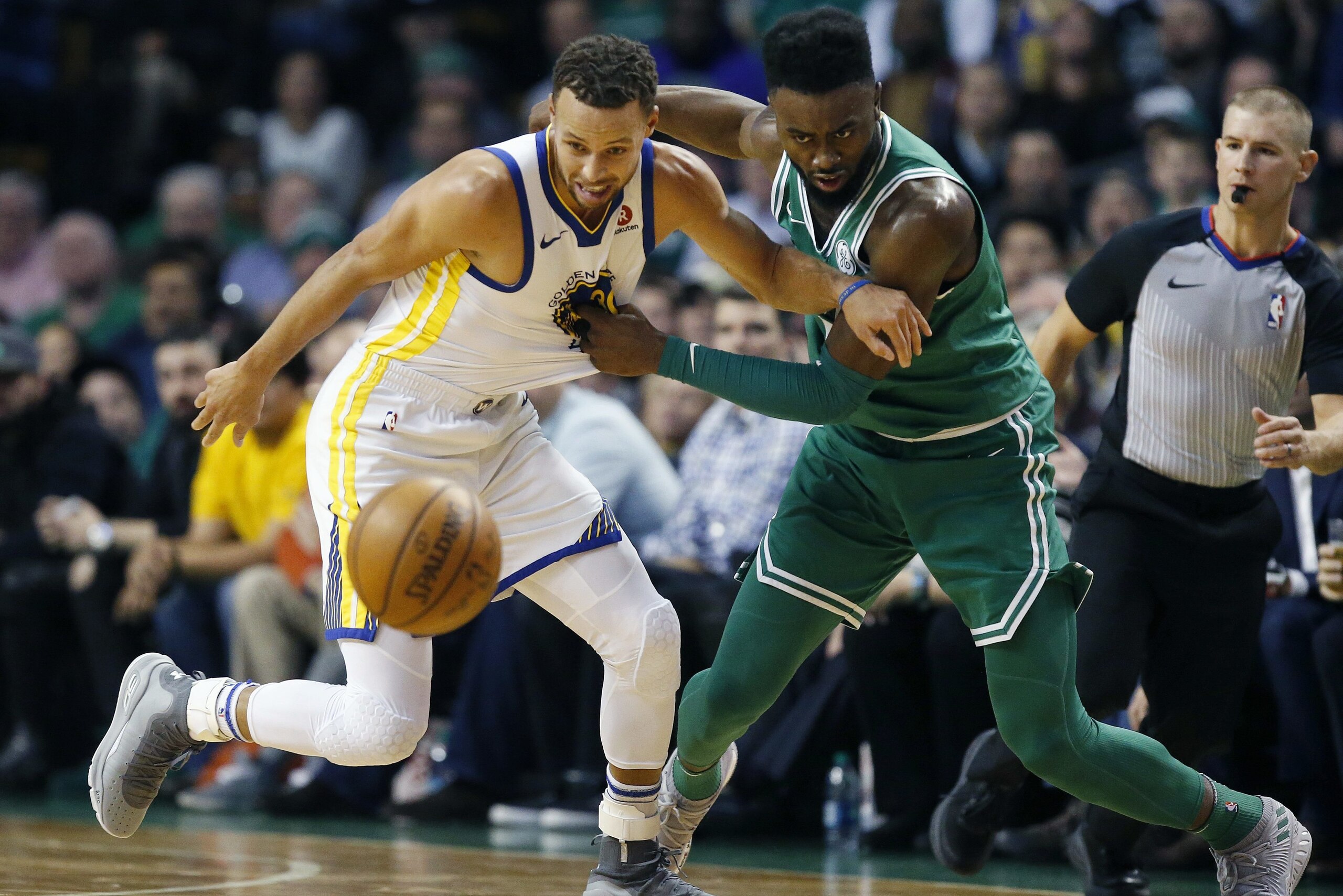Boston Celtics' Jaylen Brown (7) and Golden State Warriors' Stephen Curry battle for a loose ball during the first quarter of an NBA basketball game in Boston, Thursday, Nov. 16, 2017. (AP Photo/Michael Dwyer)