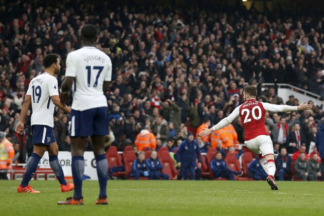 Arsenal's German defender Shkodran Mustafi (R) celebrates scoring the team's first goal as Tottenham Hotspur's Belgian midfielder Mousa Dembele (L) and Tottenham Hotspur's French midfielder Moussa Sissoko look on during the English Premier League football match between Arsenal and Tottenham Hotspur at the Emirates Stadium in London on November 18, 2017.  / AFP PHOTO / IKIMAGES / Ian KINGTON / RESTRICTED TO EDITORIAL USE. No use with unauthorized audio, video, data, fixture lists, club/league logos or 'live' services. Online in-match use limited to 45 images, no video emulation. No use in betting, games or single club/league/player publications.  /         (Photo credit should read IAN KINGTON/AFP/Getty Images)