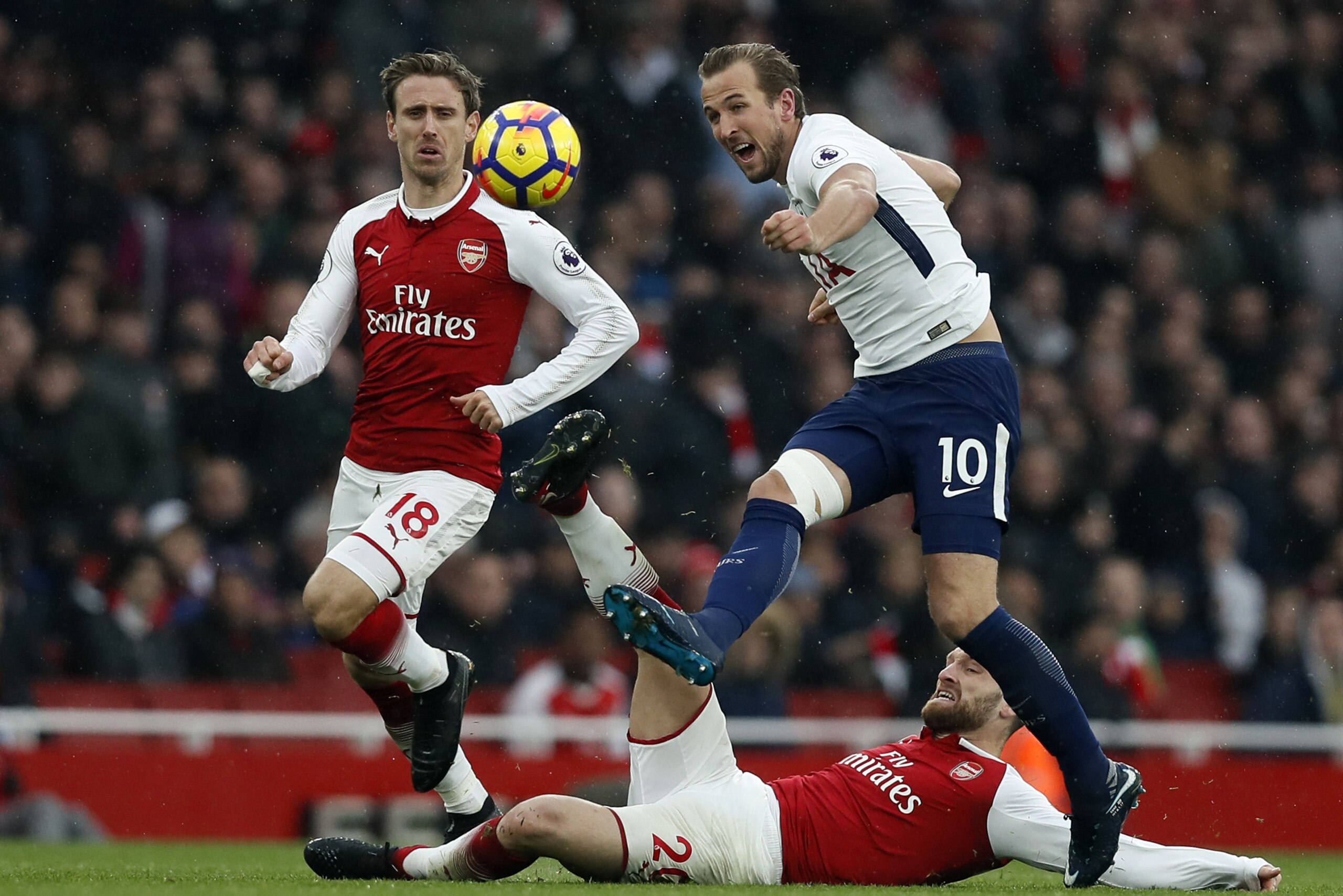 Tottenham's Harry Kane, right, is challenged by Arsenal's Shkodran Mustafi and Arsenal's Nacho Monreal, left, during the English Premier League soccer match between Arsenal and Tottenham Hotspur at Emirates stadium in London, Saturday, Nov. 18, 2017. (AP Photo/Kirsty Wigglesworth)