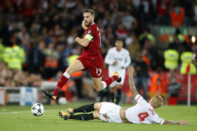 Liverpool's Jordan Henderson, top, is tackled by Sevilla's Simon Kjaer during the Champions League group E soccer match between Liverpool and Sevilla at Anfield stadium in Liverpool, England, Wednesday, Sept. 13, 2017. (AP Photo/Frank Augstein)
