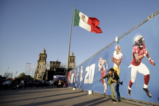 Fans interact during NFL football's Fan Fest at Zocalo Square Saturday, Nov. 18, 2017, in Mexico City. Thousands of football fans descended on the city's historic main plaza Saturday, one day before the New England Patriots face the Oakland Raiders in a football game at Aztec Stadium. (AP Photo/Gregory Bull)