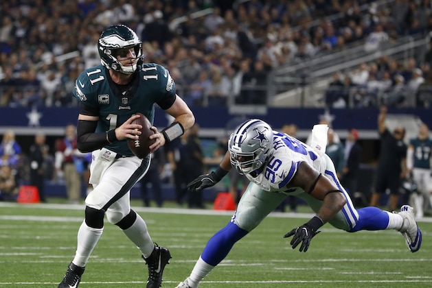 Philadelphia Eagles quarterback Carson Wentz (11) evades pressure from Dallas Cowboys' David Irving (95) before throwing a pass for a two-point conversion to wide receiver Alshon Jeffery in the second half of an NFL football game, Sunday, Nov. 19, 2017, in Arlington, Texas. (AP Photo/Ron Jenkins)
