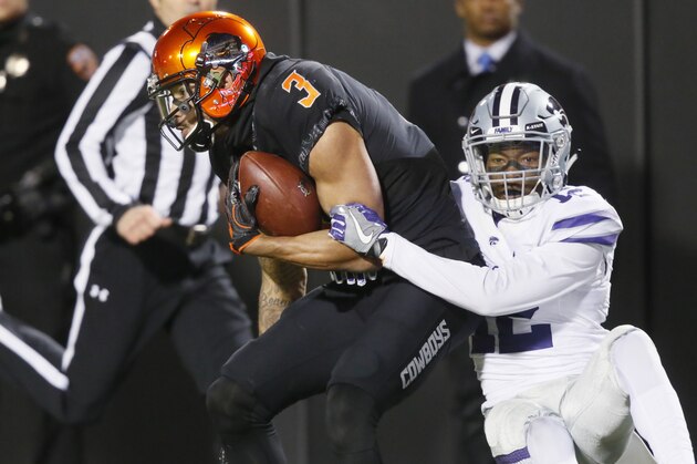 Oklahoma State wide receiver Marcell Ateman, left, is tackled by Kansas State defensive back A.J. Parker (12) in the second half of an NCAA college football game in Stillwater, Okla., Saturday, Nov. 18, 2017. Kansas State won 45-40.(AP Photo/Sue Ogrocki)