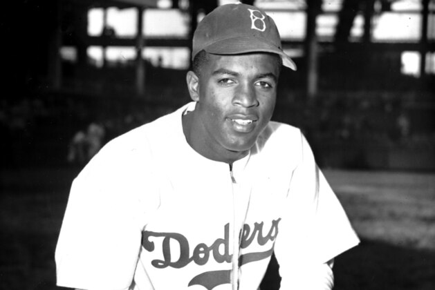 FILE - In this April 11, 1947 file photo, Jackie Robinson of the Brooklyn Dodgers poses at Ebbets Field in the Brooklyn borough of New York. A specially padded baseball cap that Jackie Robinson wore for protection against beanballs has sold for $590,994 at auction.The blue Brooklyn Dodgers hat sold Saturday, Oct. 28, 2017, after a monthlong online auction through the sports auctioneers Lelands. Lelands says Robinson wore the hat when he broke baseball’s color barrier in 1947. (AP Photo/John Rooney, File)
