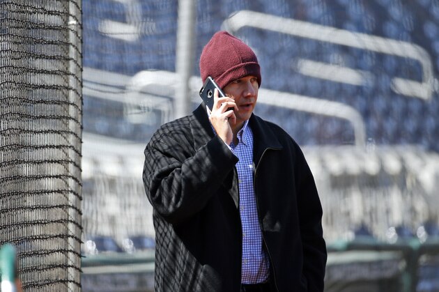 Atlanta Braves general manager John Coppolella talks on the phone before a baseball game against the Washington Nationals at Nationals Park, Wednesday, April 13, 2016, in Washington. Braves outfielder Hector Olivera was placed on paid administrative leave by Major League Baseball after he was arrested when a woman accused him of assault at a hotel outside Washington. (AP Photo/Alex Brandon)