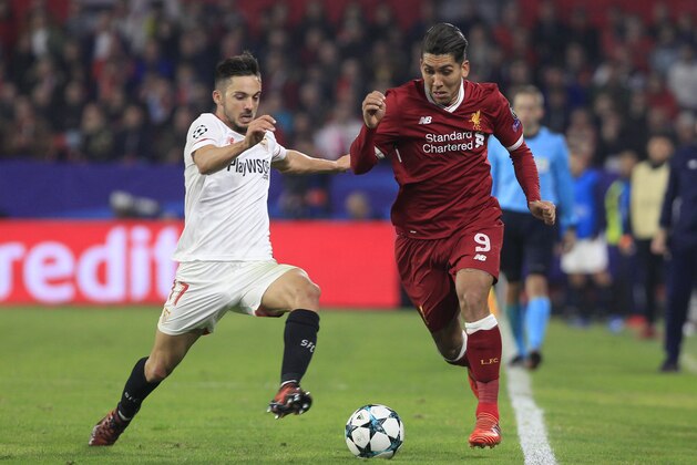 Liverpool's Roberto Firmino, right, runs with the ball past Sevilla's Pablo Sarabia during a Champions League group E soccer match between Sevilla and Liverpool, at the Ramon Sanchez Pizjuan stadium in Seville, Spain, Tuesday, Nov. 21, 2017. (AP Photo/Miguel Morenatti)