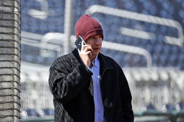Atlanta Braves general manager John Coppolella talks on the phone before a baseball game against the Washington Nationals at Nationals Park, Wednesday, April 13, 2016, in Washington. Braves outfielder Hector Olivera was placed on paid administrative leave by Major League Baseball after he was arrested when a woman accused him of assault at a hotel outside Washington. (AP Photo/Alex Brandon)