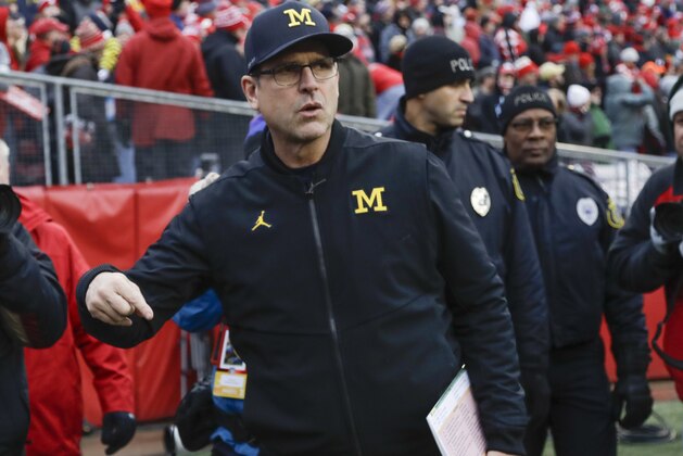 Michigan head coach Jim Harbaugh leads his team to the field before an NCAA college football game against the WisconsinSaturday, Nov. 18, 2017, in Madison, Wis. (AP Photo/Morry Gash)