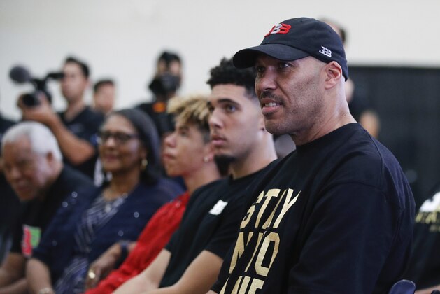 FILE - In this June 23, 2017, file photo, LaVar Ball, right, father of Los Angeles Lakers draft pick Lonzo Ball, listens to his son during the NBA basketball team's news conference in El Segundo, Calif. Ball questioned the extent of President Donald Trump’s involvement in securing his son’s release from the custody of Chinese authorities during a combative 20-minute CNN interview on Monday, Nov. 20, 2017. (AP Photo/Jae C. Hong, File)