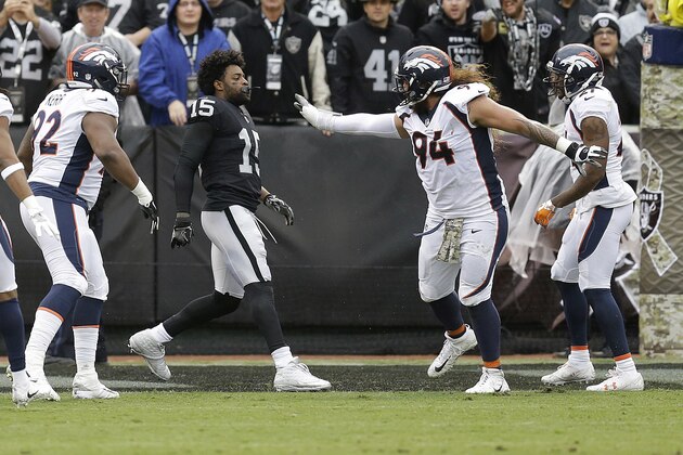 Oakland Raiders wide receiver Michael Crabtree, center, fights with Denver Broncos nose tackle Domata Peko (94), nose tackle Zach Kerr (92) and cornerback Aqib Talib (21) during the first half of an NFL football game in Oakland, Calif., Sunday, Nov. 26, 2017. Crabtree and Talib were ejected. (AP Photo/Ben Margot)