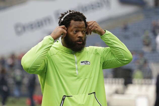 Seattle Seahawks defensive end Michael Bennett wears headphones as he stands on the field during warmups before an NFL football game against the Houston Texans, Sunday, Oct. 29, 2017, in Seattle. (AP Photo/Elaine Thompson)